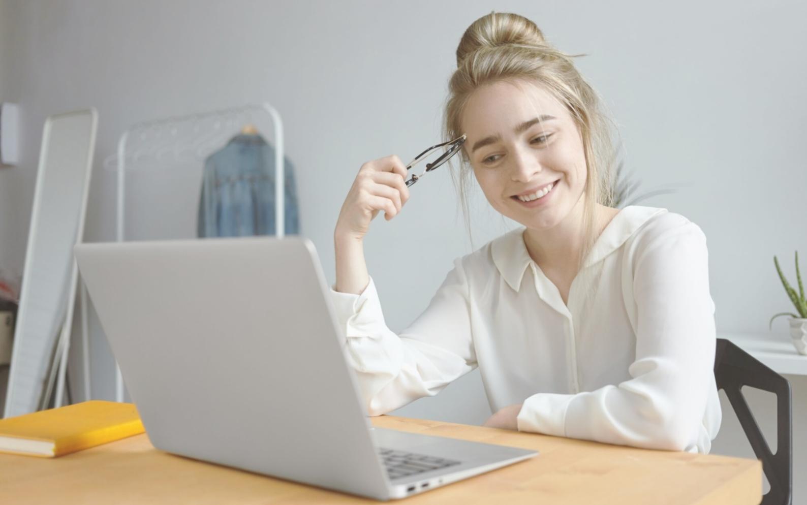 Modern classroom setting with students collaborating on financial modeling projects using laptops and whiteboards